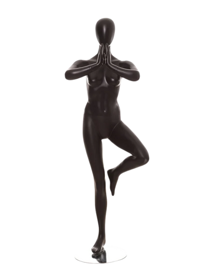 A glossy black female mannequin figure posed in a yoga tree pose on a plain white background.