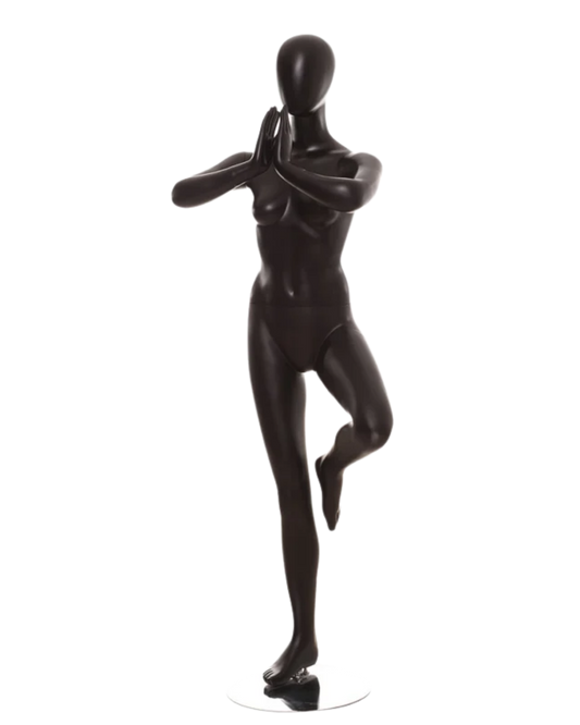 A glossy black mannequin figure posed in a yoga tree pose on a small round base, photographed against a plain white background.