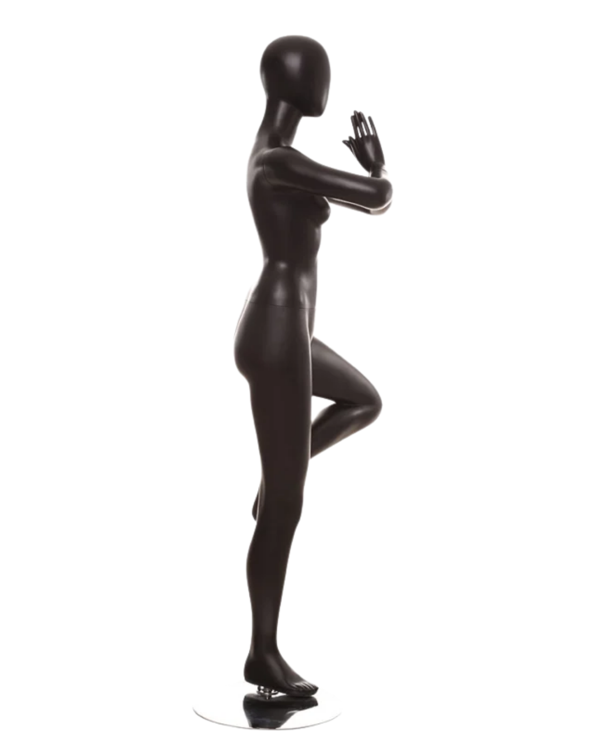 A glossy black female mannequin statue in a yoga tree pose, standing on a small round base against a plain white background.
