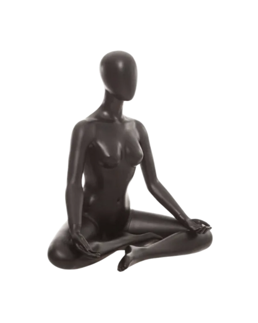 A glossy black mannequin figurine shaped like a seated female form, posed in a meditative cross-legged position against a plain white background.